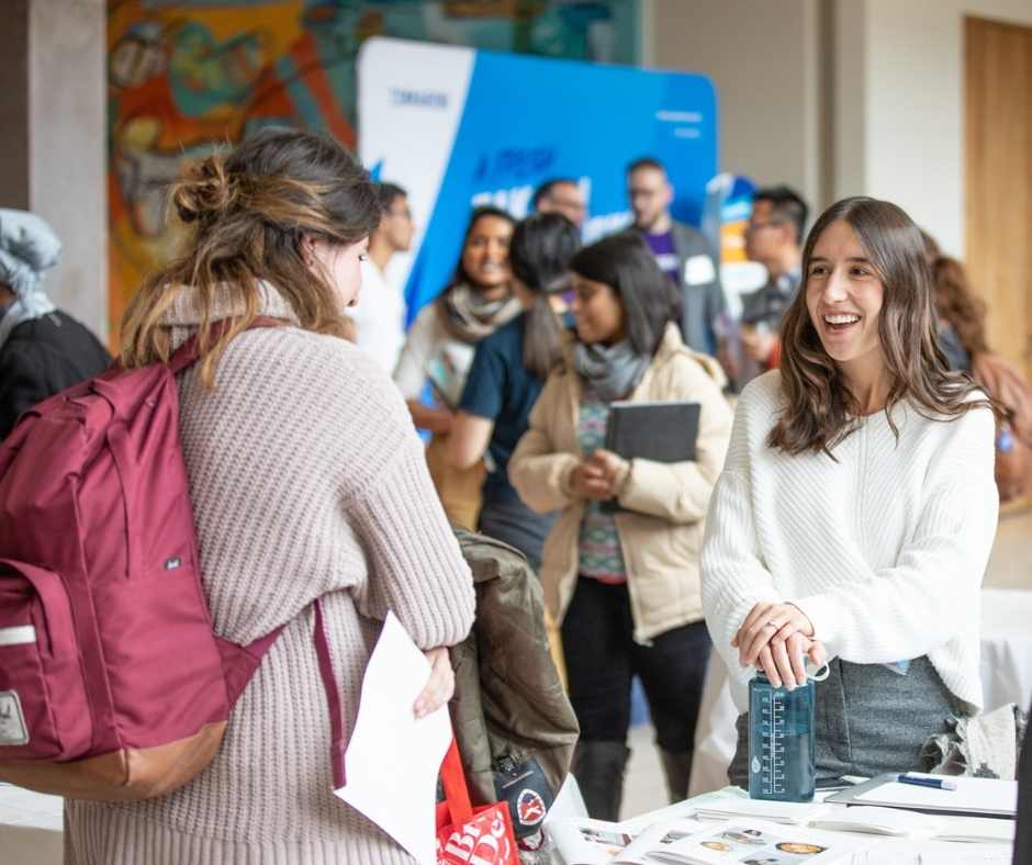 Female student entrepreneur pitching her nutritional company to a student at Startup Showcase