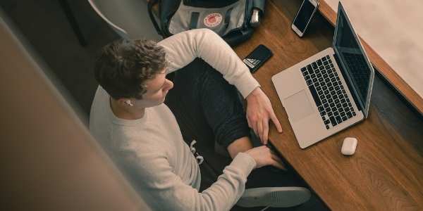 Overview Iamge Of Male Student Working On Laptop