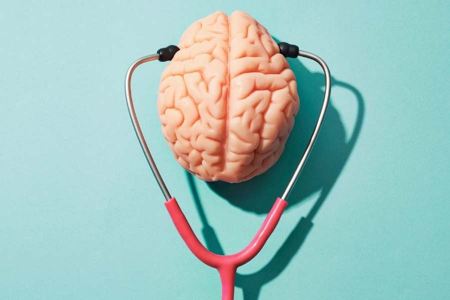 Brain with stethoscope toys on light blue background