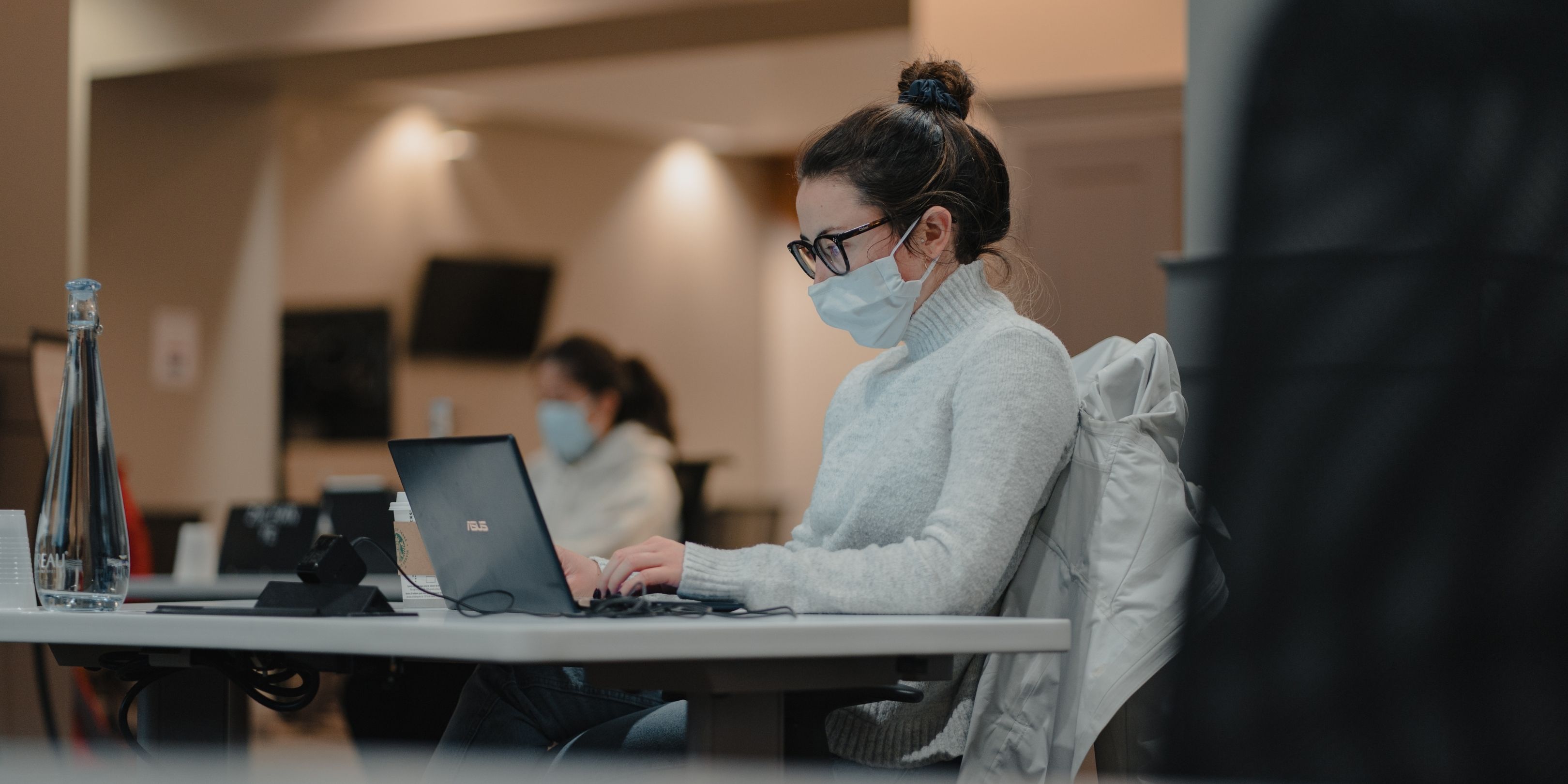 Female Student Working In Library Open Space With Mask On